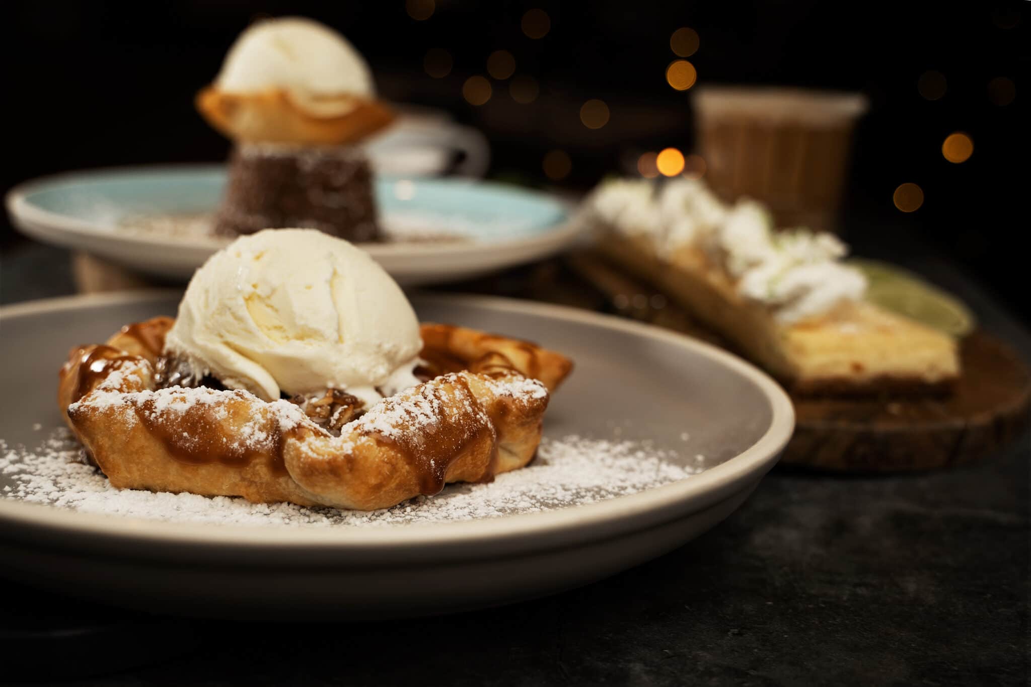 Three of Saltlik's desserts showcased in a dark moody photo.