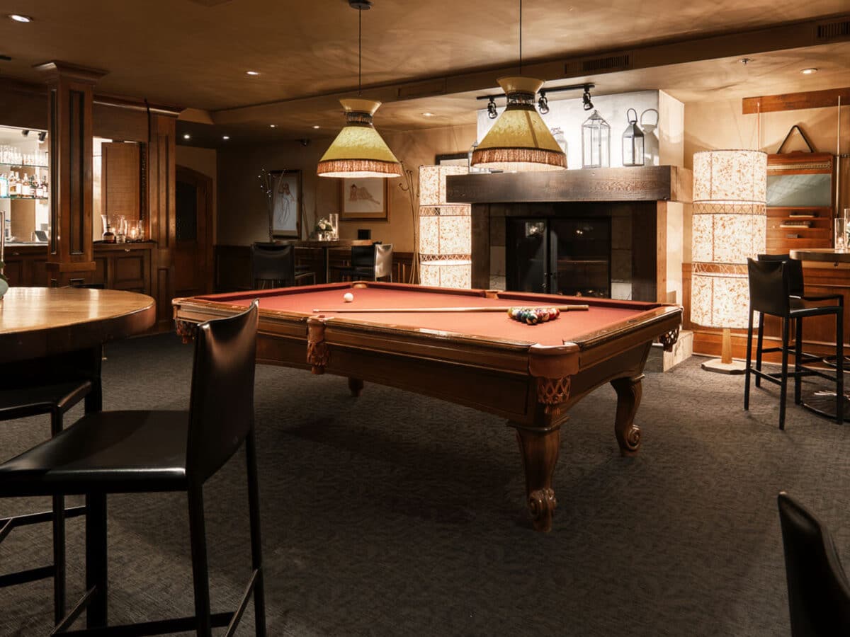 A photo of one of Saltlik's basement event spaces with a pool table, bar tables, and a fireplace.